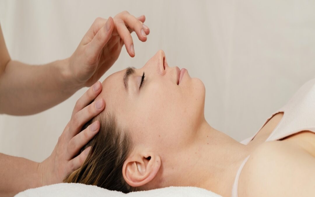 Especialista realizando masajes capilares sobre una joven mujer relajada